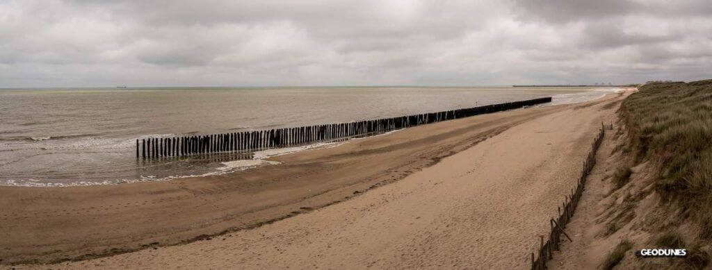 Rangé de pieux disposée parallèlement au trait de côte permet d’atténuer la propagation de la houle. La position du niveau de l’eau sur ce cliché témoigne d’une légère accumulation en arrière du dispositif.