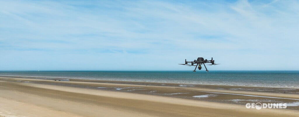 Cette image saisissante capture le drone Matrice 300 en plein vol au-dessus de la magnifique plage de Zuydcoote. Cette vue aérienne offre une perspective unique de cette région côtière, mettant en lumière les potentialités de la technologie drone pour la surveillance et la cartographie des environnements côtiers.